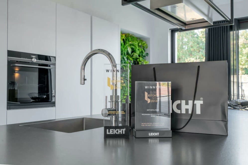 De twee glazen onderscheidingen van de Global Kitchen Design Award 2018 op LEICHT-sokkels, met de tekst Winner, Netherlands en Wildhagen Breda
