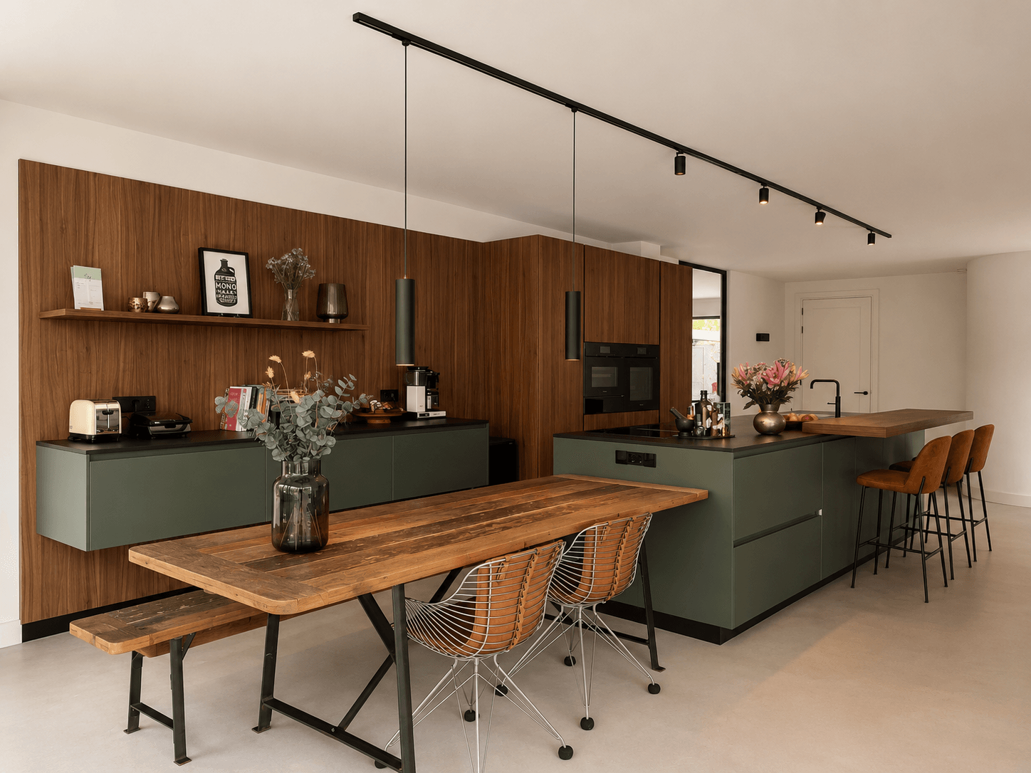 Maatwerk woonkeuken met een walnoten kastenwand, diepgroene glazen fronten en een Dekton-werkblad in Sirius, geleverd door Wildhagen