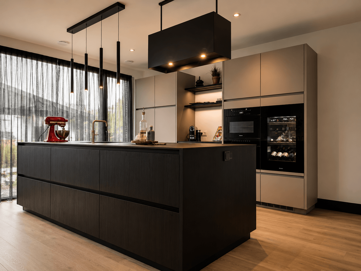 Maatwerk designkeuken met een zwart eiken kookeiland en taupegrijze Fenix-fronten, geleverd door Wildhagen