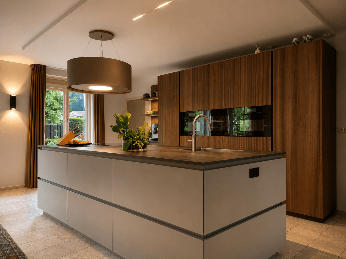 Maatwerk designkeuken met een walnoten kastenwand en een taupegrijs Fenix-eiland, geleverd door Wildhagen
