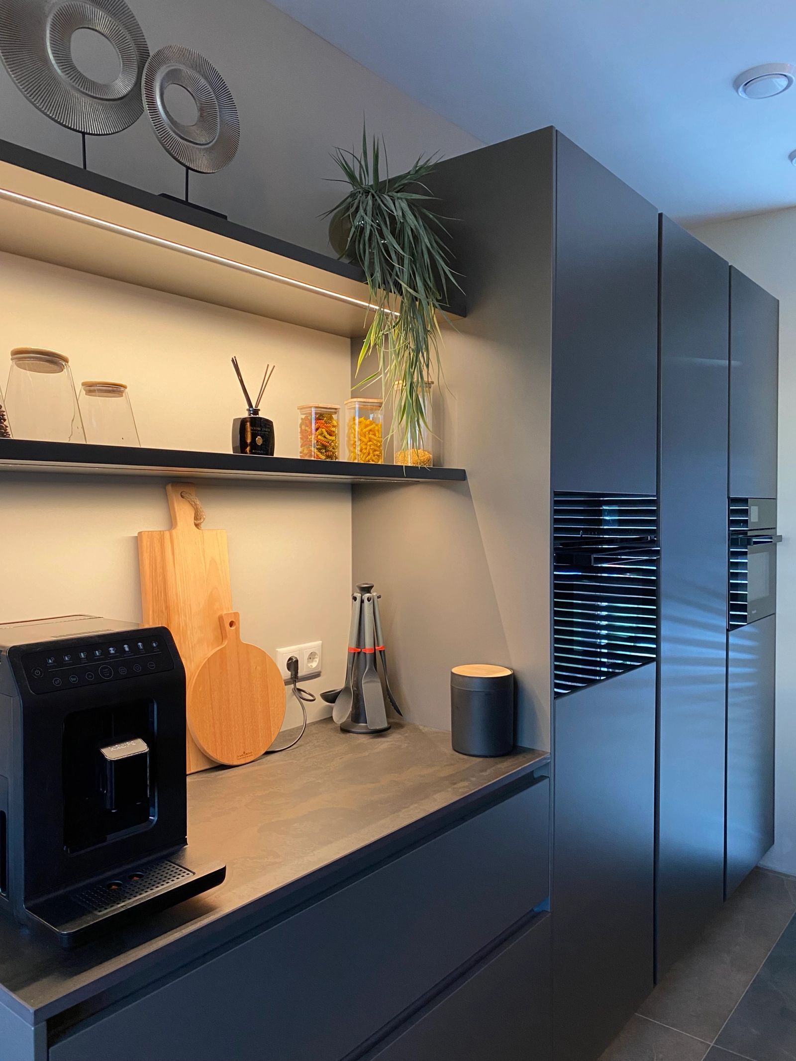 Koffiecorner met open nis in de donkere kastenwand
